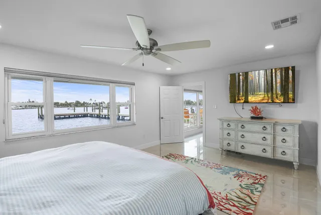 a view of a bedroom with wooden floor and windows