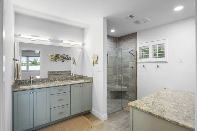 a bathroom with a shower sink vanity mirror and toilet