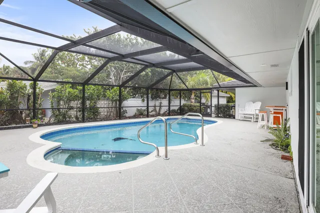 a front view of a house with a garden and swimming pool