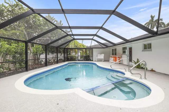 a view of a house with a yard and potted plants