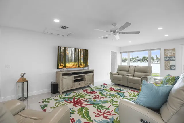 a kitchen with stainless steel appliances granite countertop a stove top oven a sink dishwasher a refrigerator and white cabinets with wooden floor