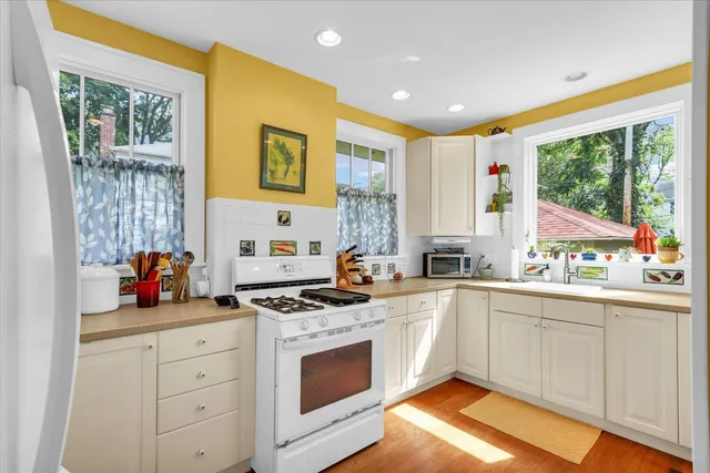 a kitchen with stainless steel appliances granite countertop a stove a sink and a refrigerator