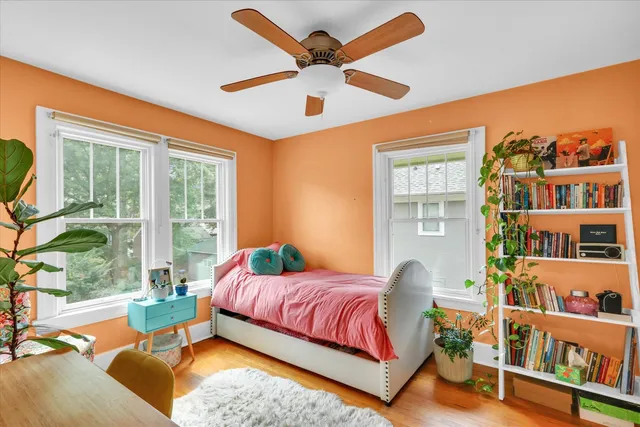 a bedroom with a bed and a large window with the outer view