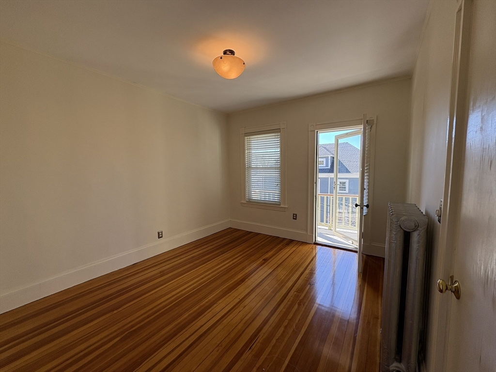 62 Ibbetson Street, Unit 3L Somerville, MA 02143 - Photo 5 of 20 wooden floor in an empty room with a window