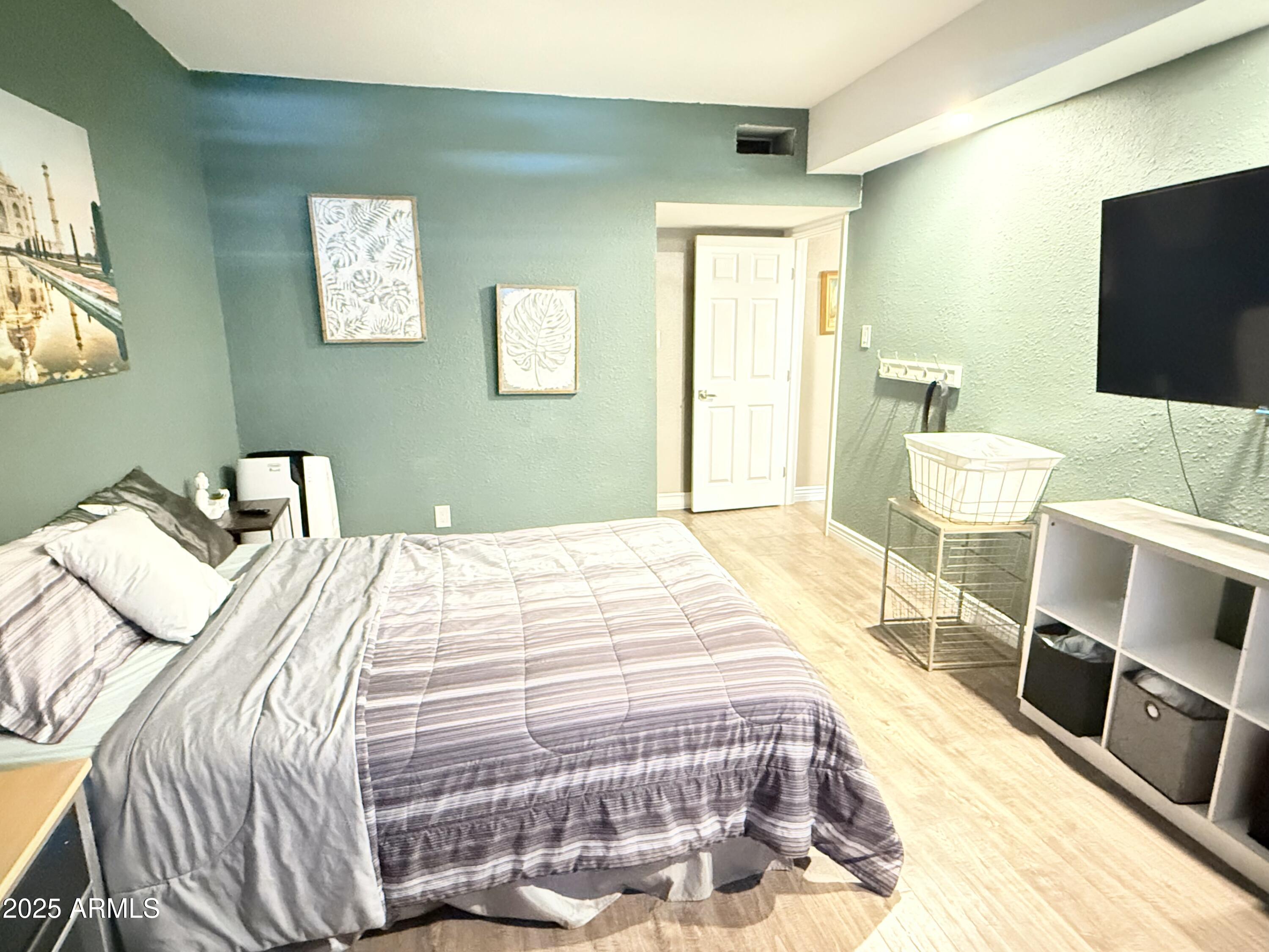 357 East Thomas Road, Unit A105 Phoenix, AZ 85012 - Photo 25 of 51 a bedroom with a bed and flat screen tv