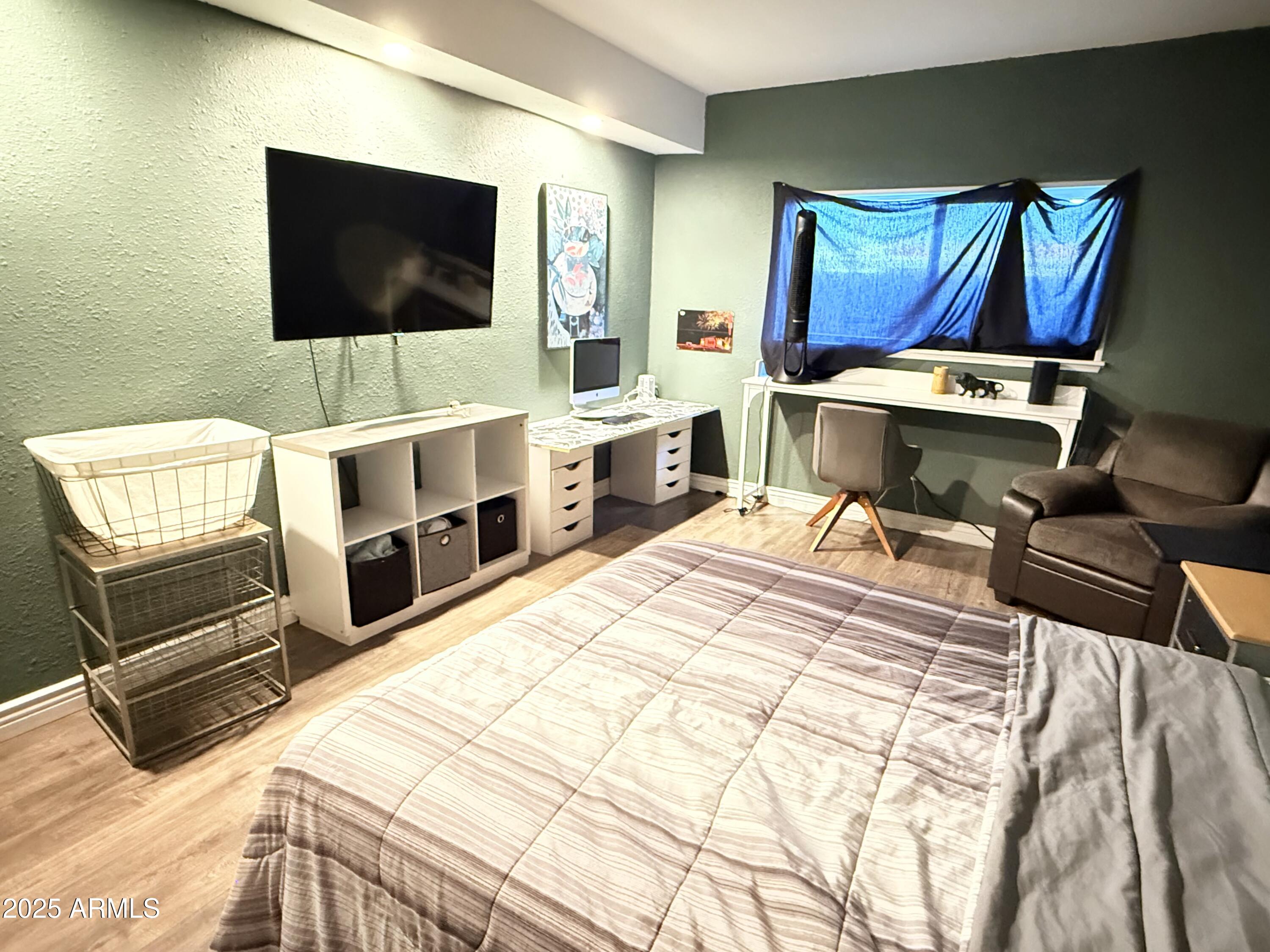 357 East Thomas Road, Unit A105 Phoenix, AZ 85012 - Photo 26 of 51 a bedroom with a bed and flat tv screen on wall