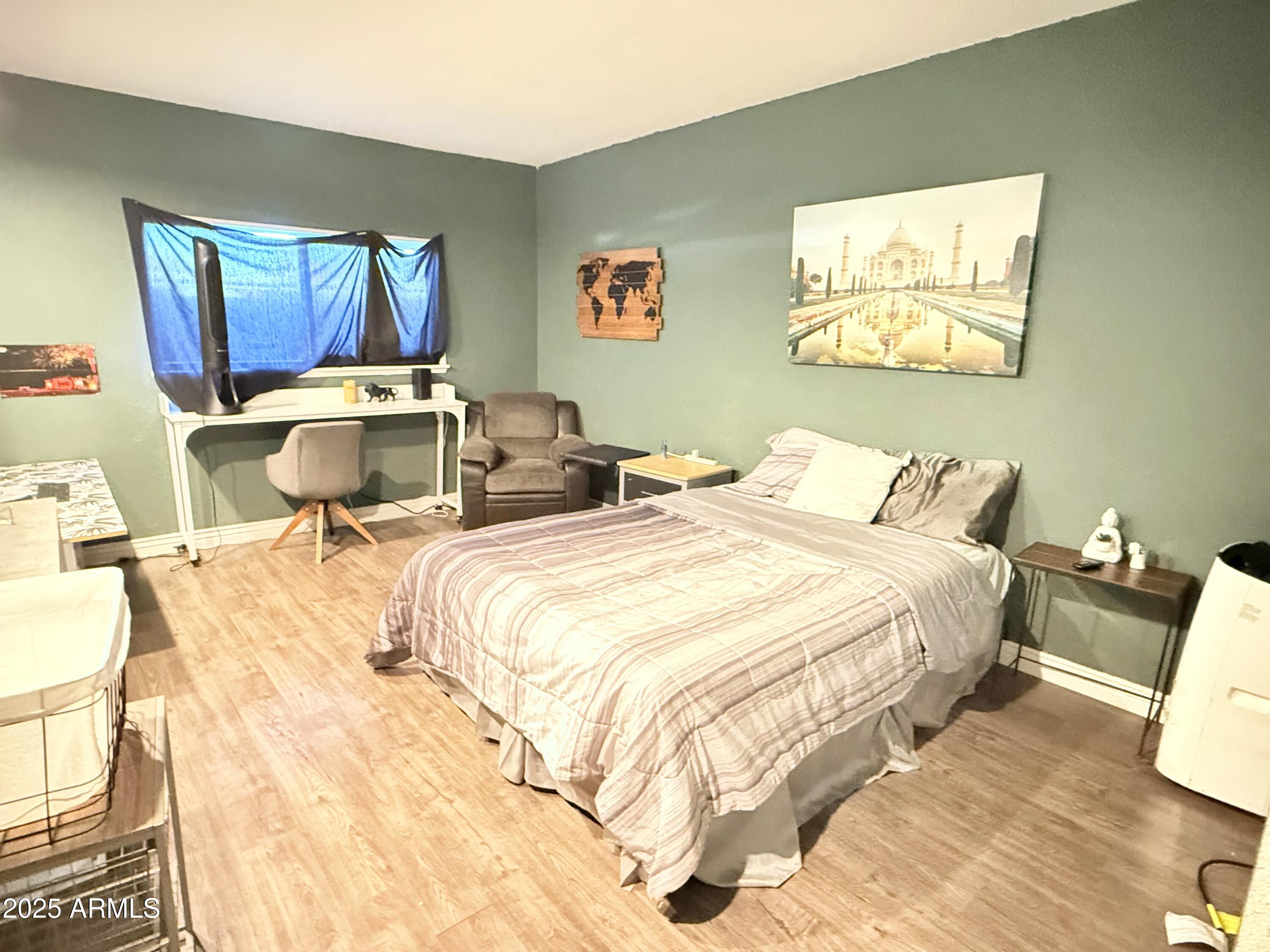 357 East Thomas Road, Unit A105 Phoenix, AZ 85012 - Photo 27 of 51 a bedroom with a bed and wooden floor