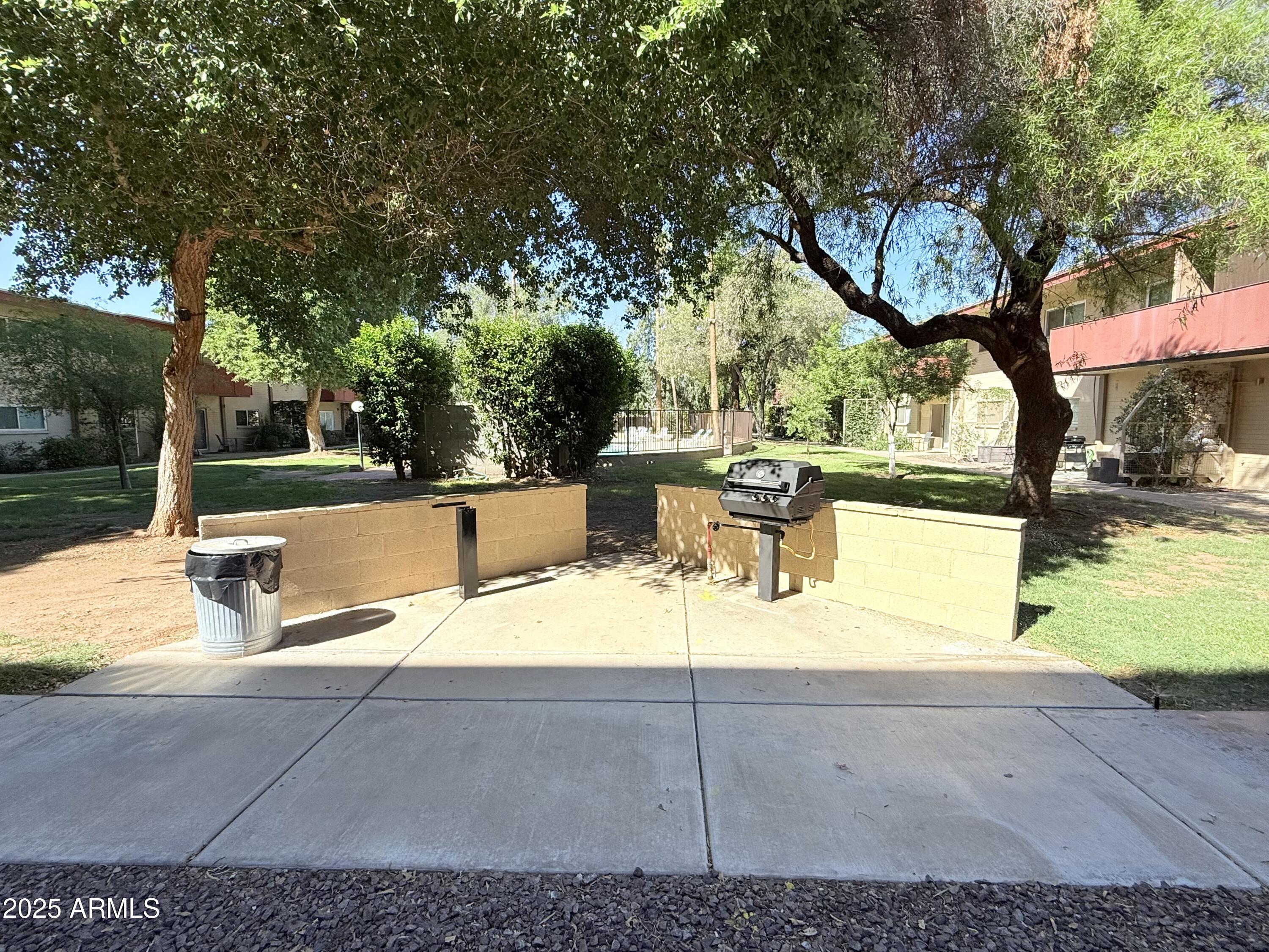 357 East Thomas Road, Unit A105 Phoenix, AZ 85012 - Photo 42 of 51 a view of a yard with table and chairs and floor to ceiling window