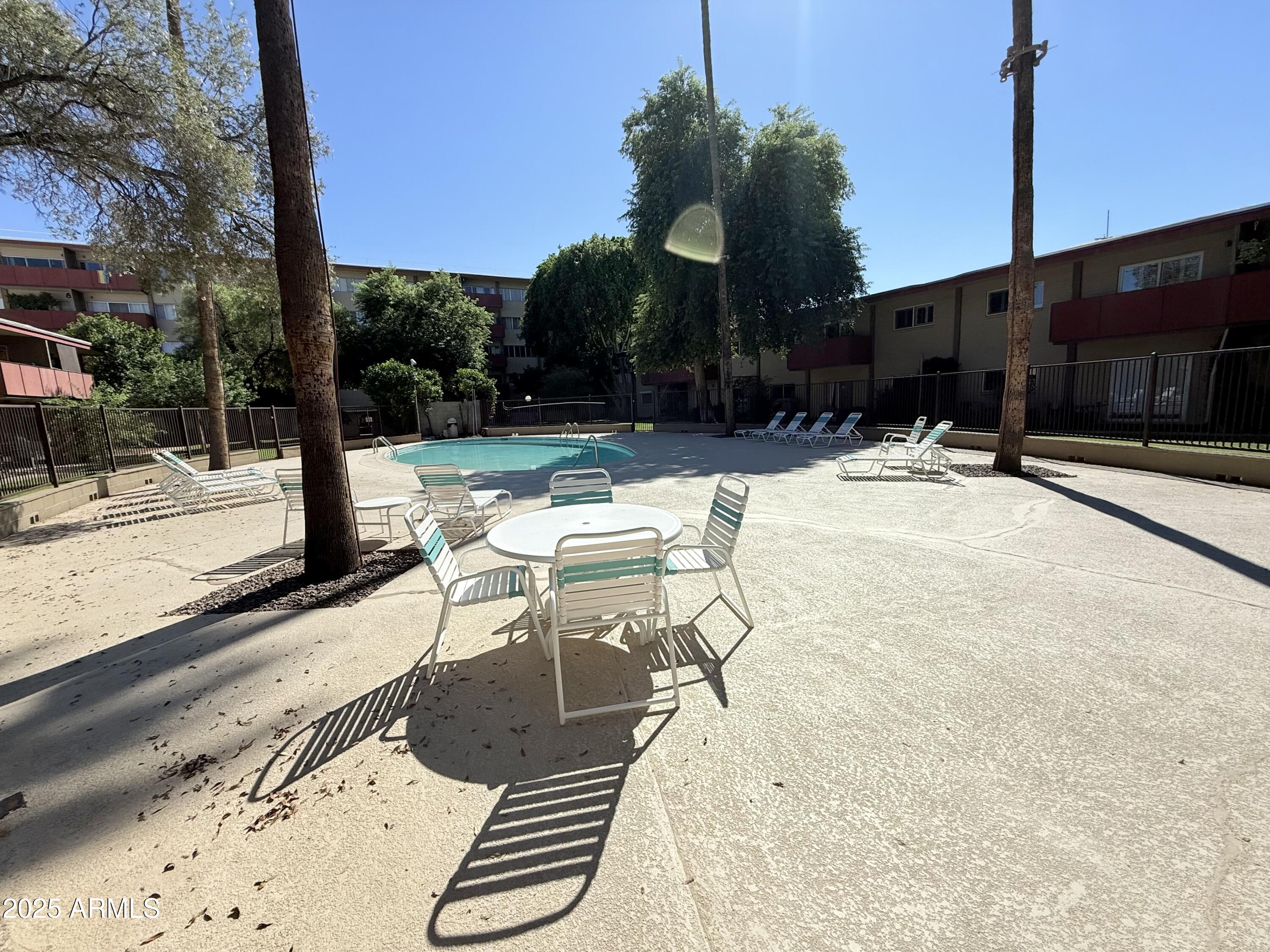 357 East Thomas Road, Unit A105 Phoenix, AZ 85012 - Photo 48 of 51 a view of a patio with table and chairs with wooden floor and fence