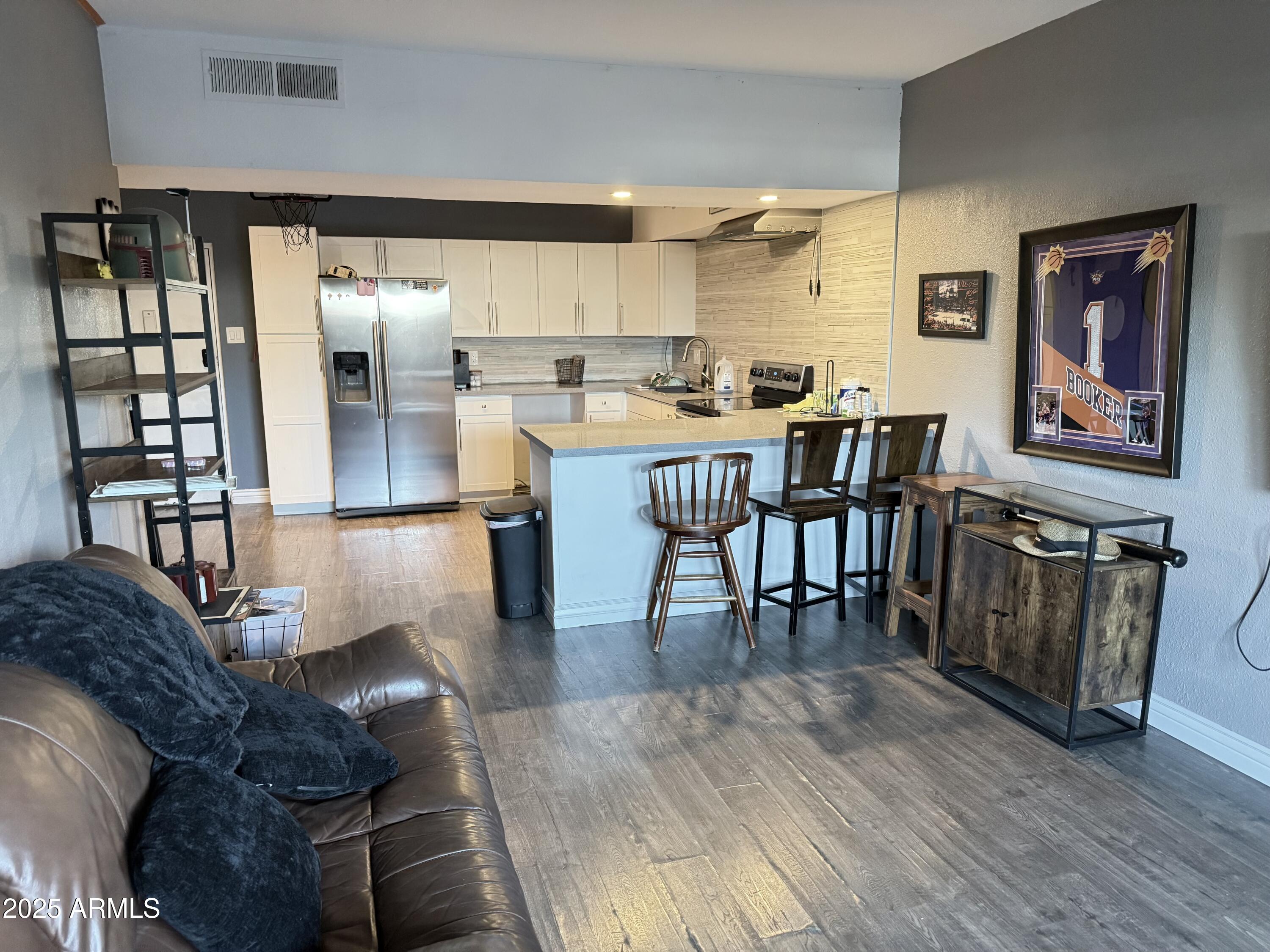 357 East Thomas Road, Unit A105 Phoenix, AZ 85012 - Photo 5 of 51 a living room with couches and kitchen view with wooden floor