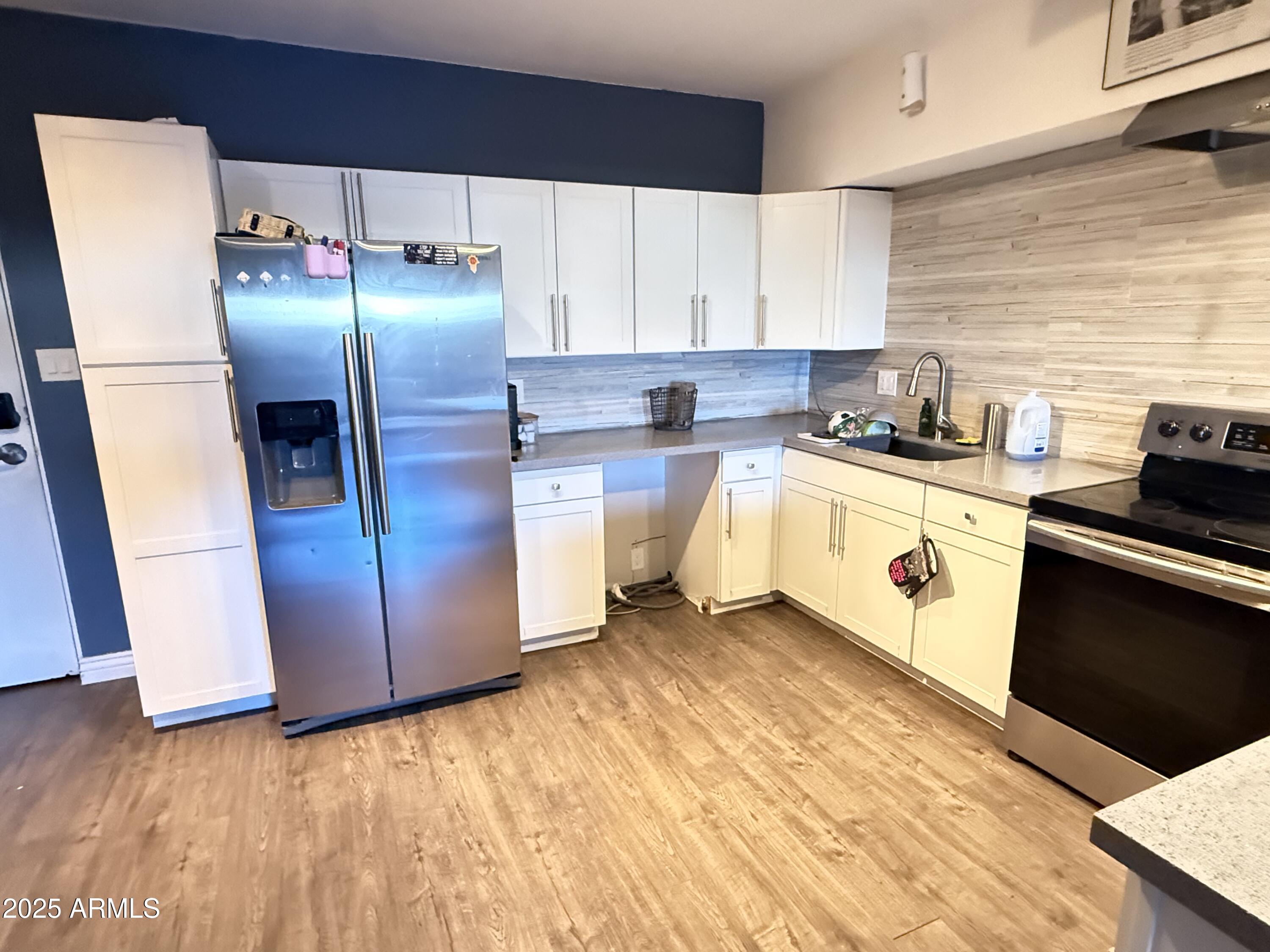 357 East Thomas Road, Unit A105 Phoenix, AZ 85012 - Photo 7 of 51 a kitchen with stainless steel appliances granite countertop a refrigerator a stove and a sink
