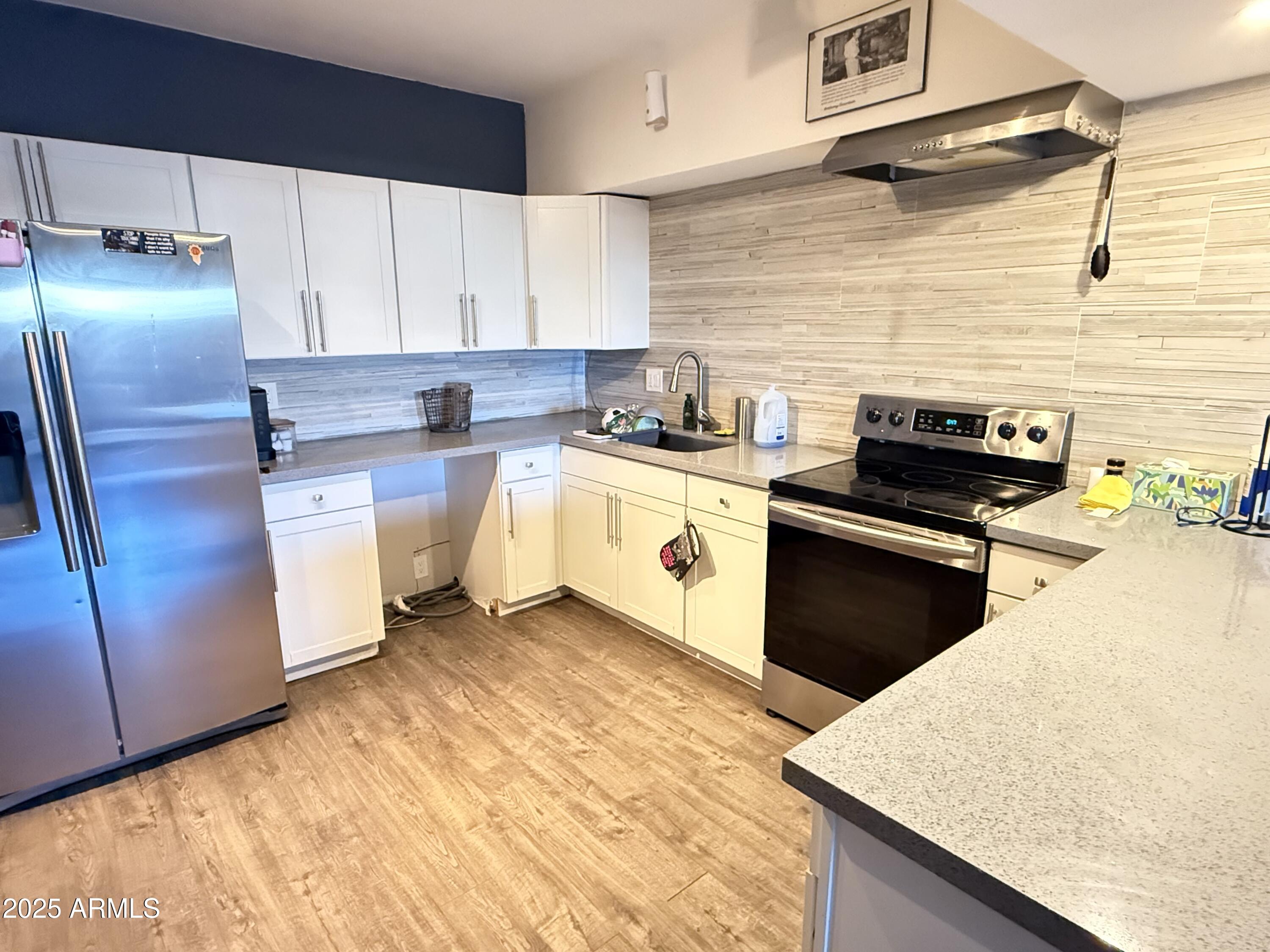 357 East Thomas Road, Unit A105 Phoenix, AZ 85012 - Photo 10 of 51 a kitchen with stainless steel appliances granite countertop a stove a sink and a refrigerator