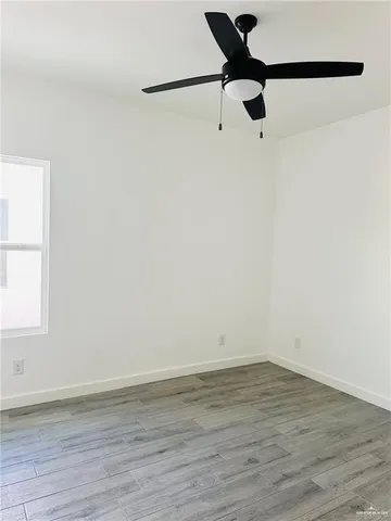 a view of a room with wooden floor and a window