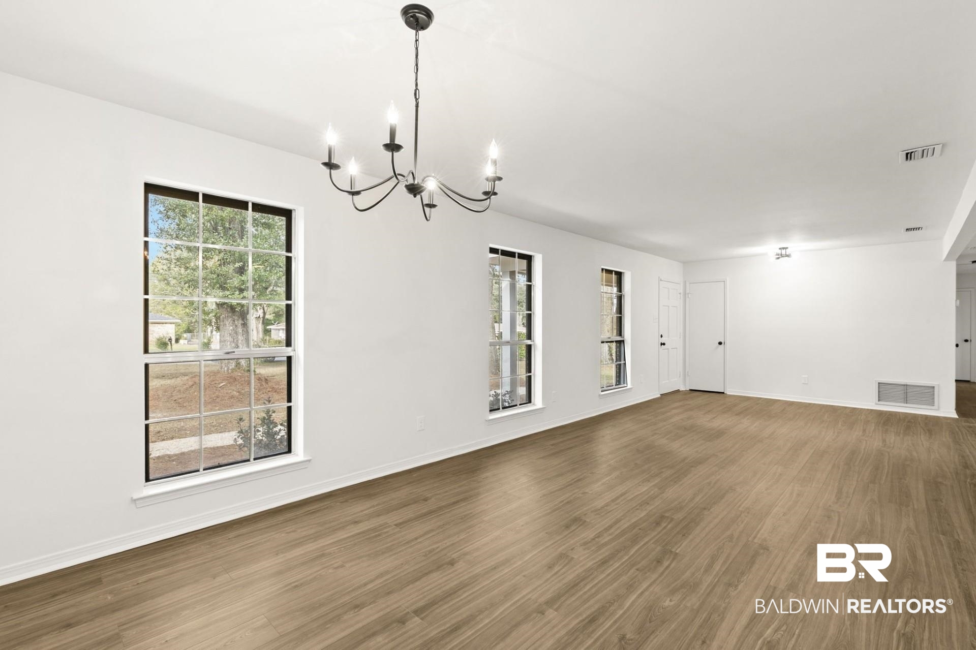 3270 Graham Road North Mobile, AL 36618 - Photo 14 of 54 Unfurnished room with an inviting chandelier, a wealth of natural light, and dark hardwood / wood-style floors