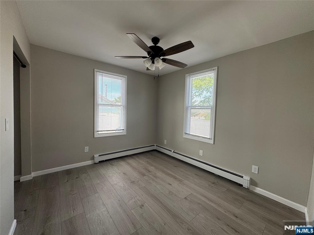 138 Carlton Avenue East Rutherford, NJ 07073 - Photo 9 of 14 an empty room with wooden floor ceiling fan and windows