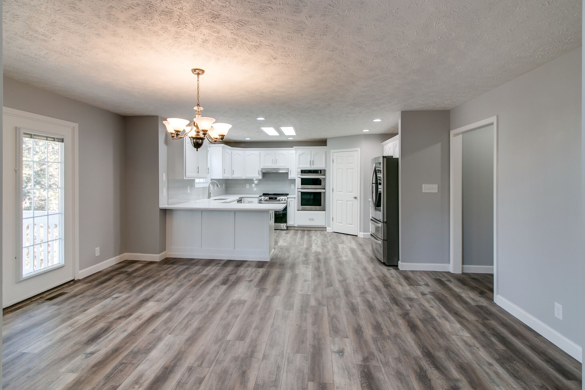 3595 Rabbit Run Trail Clarksville, TN 37043 - Photo 6 of 30 an empty room with wooden floor kitchen view and windows