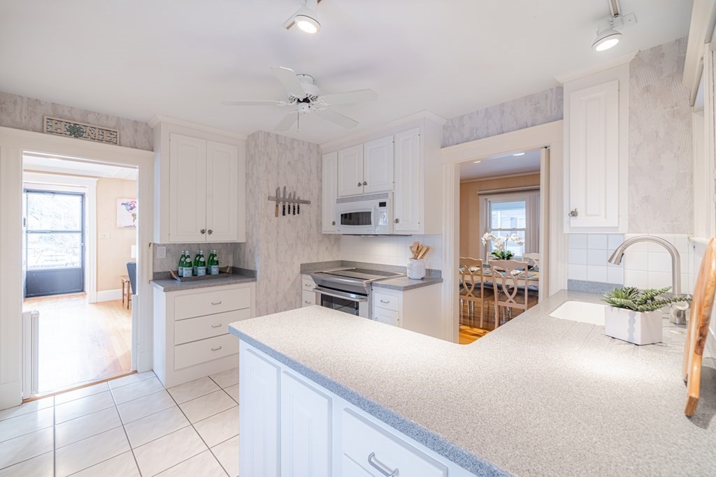 61 Nason Road Swampscott, MA 01907 - Photo 14 of 37 a kitchen with stainless steel appliances a stove top oven a sink a dining table and chairs