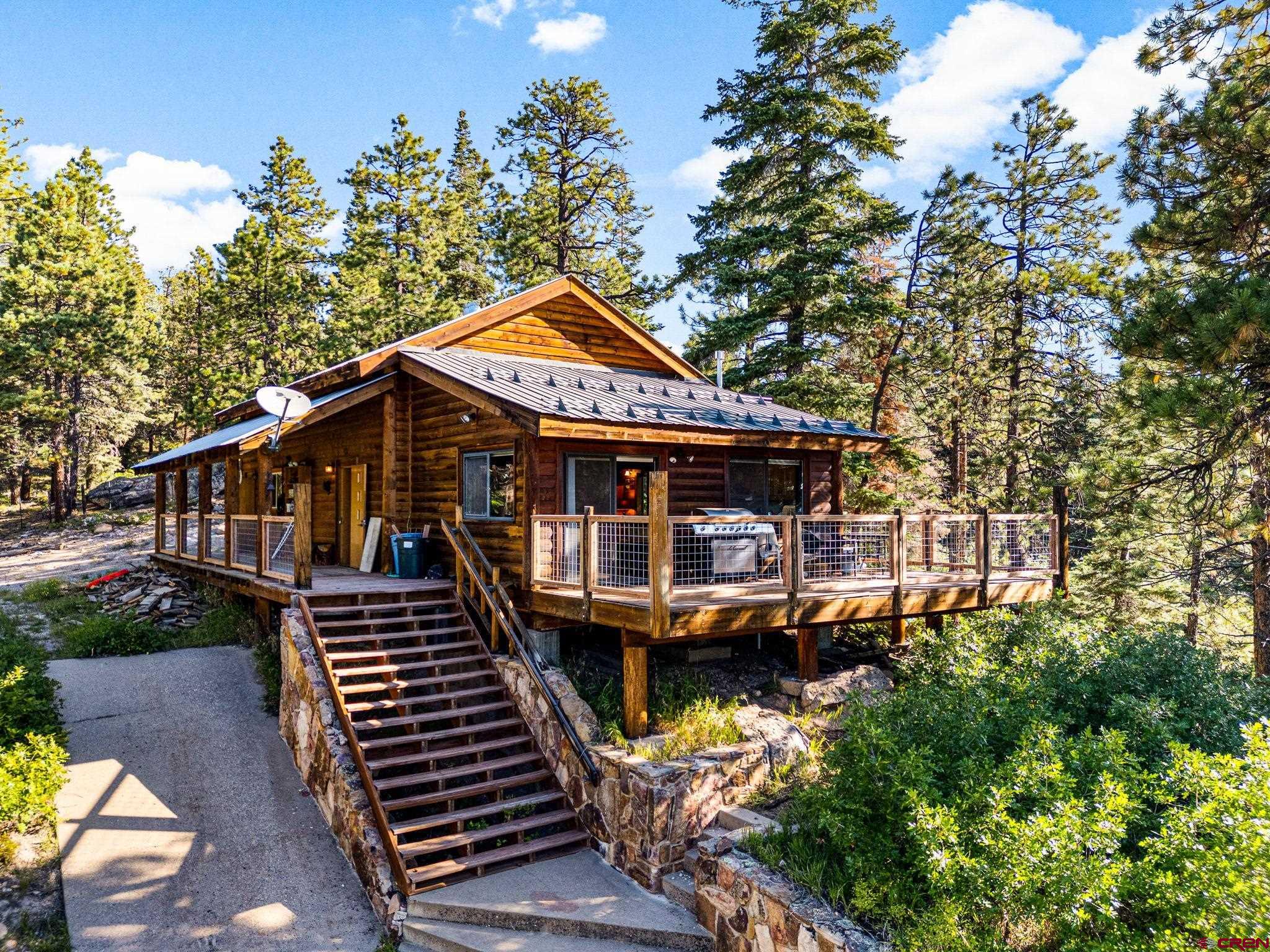 1875 Silver Mesa Driveway Durango, CO 81301 - Photo 1 of 27 a front view of a house with wooden stairs