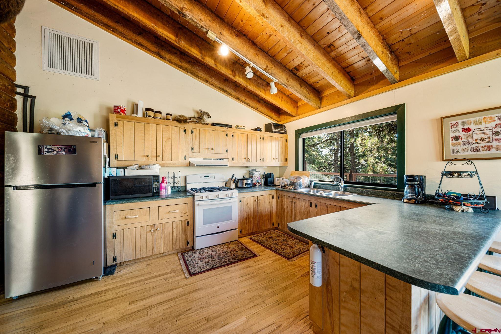 1875 Silver Mesa Driveway Durango, CO 81301 - Photo 7 of 27 a kitchen with a table chairs refrigerator and cabinets