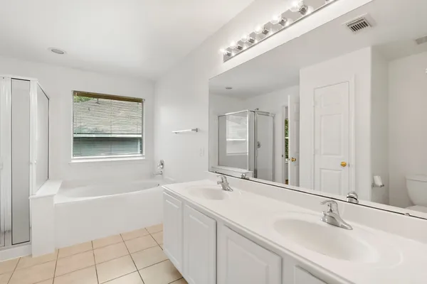 a bathroom with a tub a sink and mirror