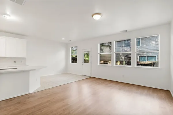 an empty room with wooden floor and windows
