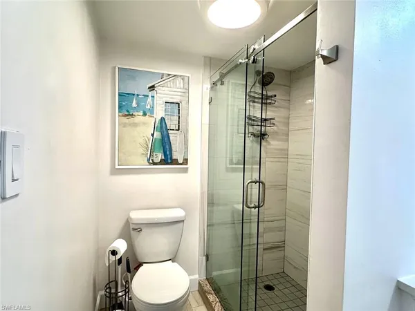 a bathroom with a granite countertop toilet a sink and a mirror