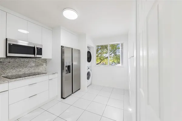 a bathroom with a granite countertop sink and a refrigerator
