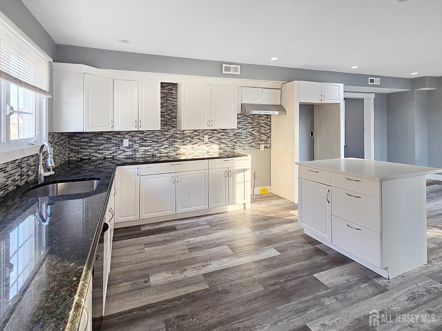 338 Runyon Avenue Middlesex, NJ 08846 - Photo 7 of 27 a kitchen with granite countertop a stove and white cabinets