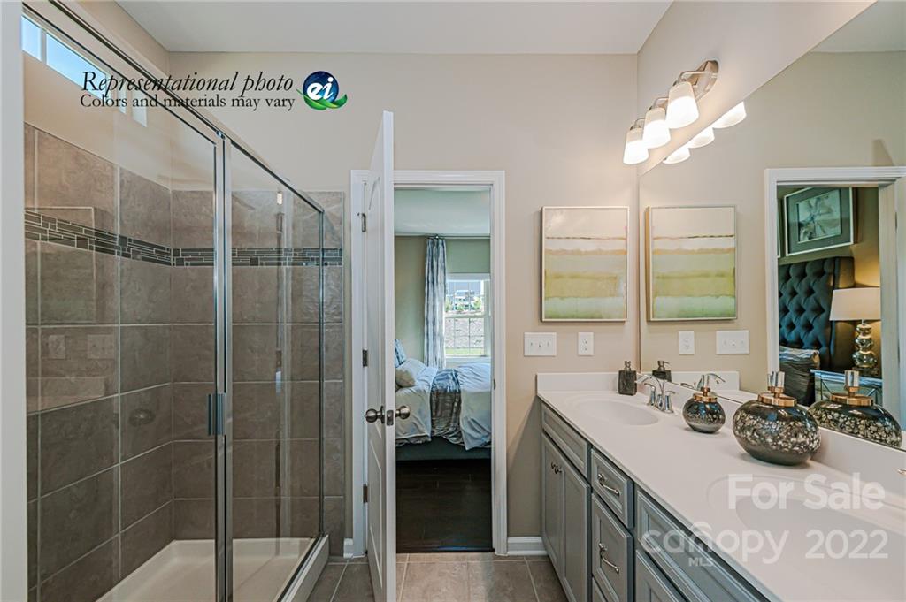 5790 Soft Shell Drive, Unit 277 Lancaster, SC 29720 - Photo 11 of 22 a bathroom with a granite countertop sink a large mirror and a shower