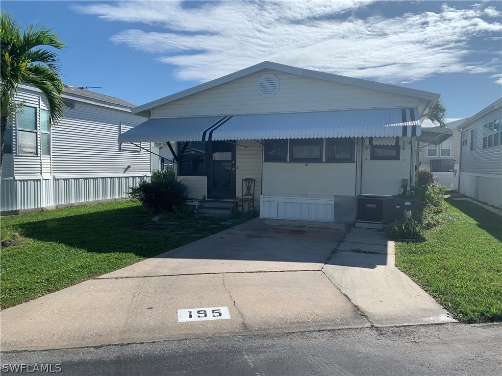 19681 Summerlin Road, Unit 195 Fort Myers, FL 33908 - Photo 1 of 12 a front view of a house with a yard and a garage