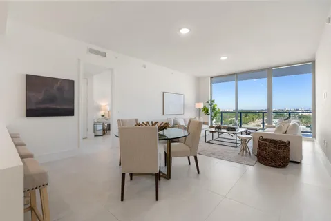a view of a livingroom with furniture and floor to ceiling window