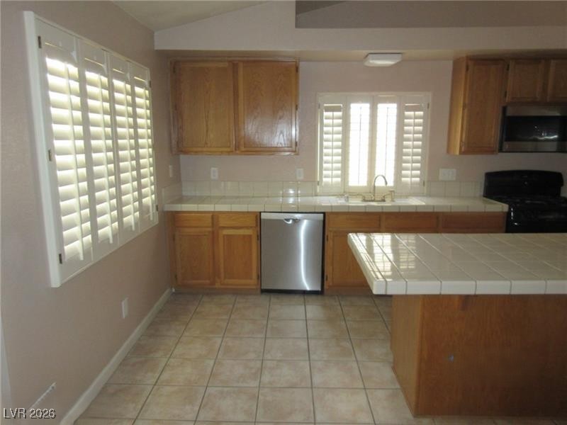 171 Enloe Street Henderson, NV 89074 - Photo 4 of 12 Kitchen with tile countertops, light tile patterned flooring, vaulted ceiling, and plantation shutters