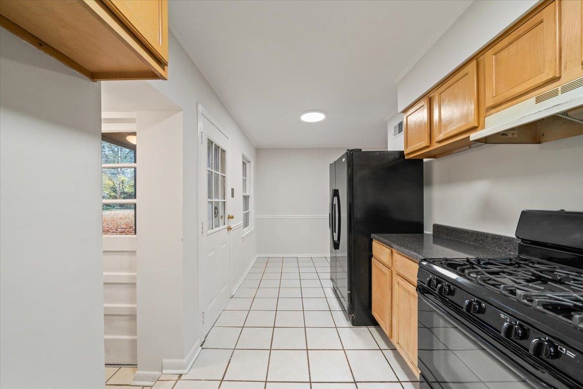 1554 Hopewell Road Memphis, TN 38117 - Photo 24 of 24 Kitchen featuring black appliances, light tile patterned floors, and under cabinet range hood