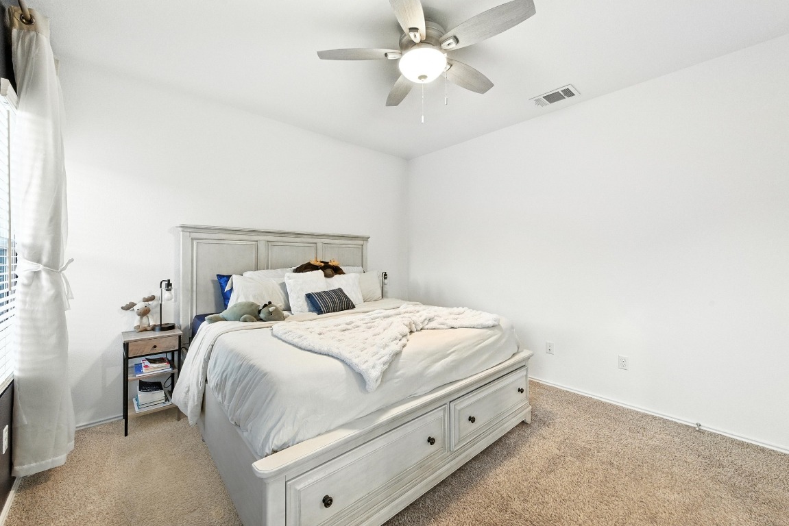 112 Cherry Ridge Road Georgetown, TX 78628 - Photo 19 of 35 a bed room with a bed and a ceiling fan