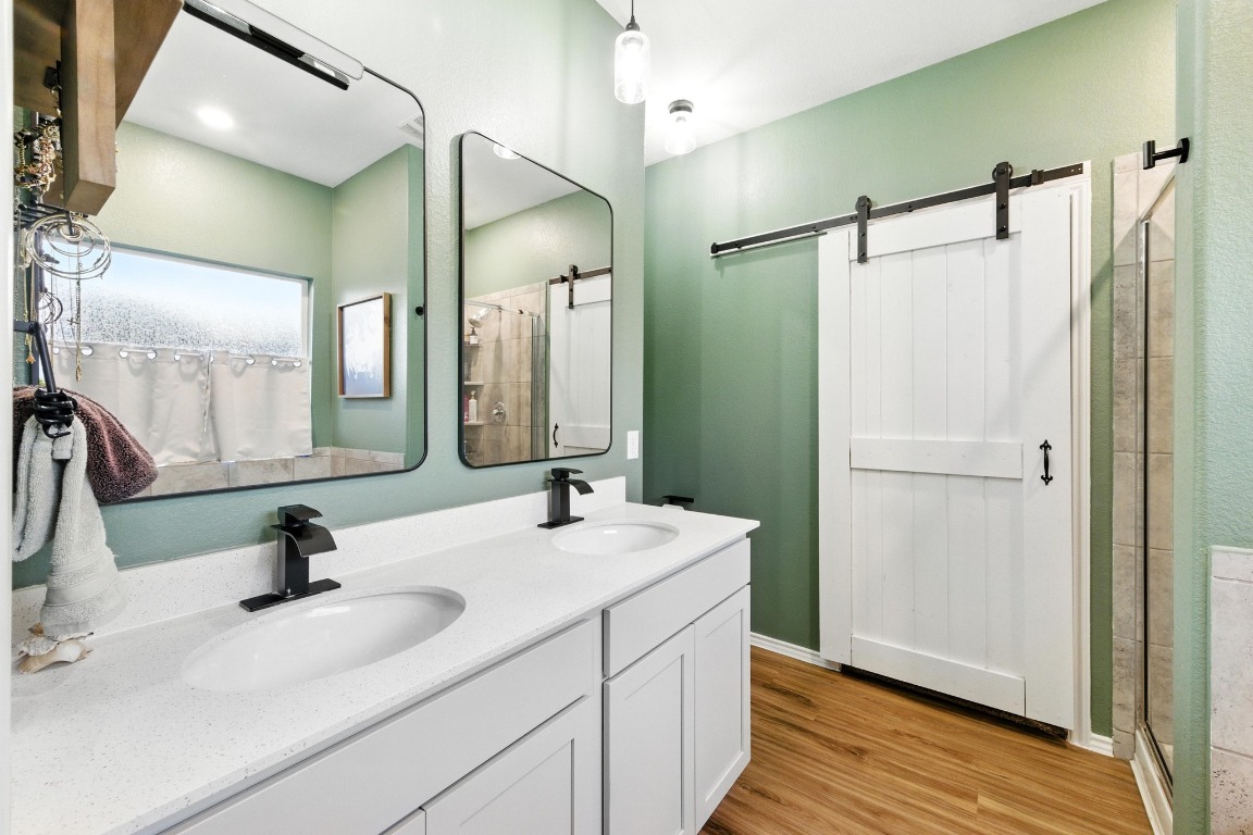 112 Cherry Ridge Road Georgetown, TX 78628 - Photo 22 of 35 Bathroom featuring double vanity, light wood-type flooring, and a shower with door