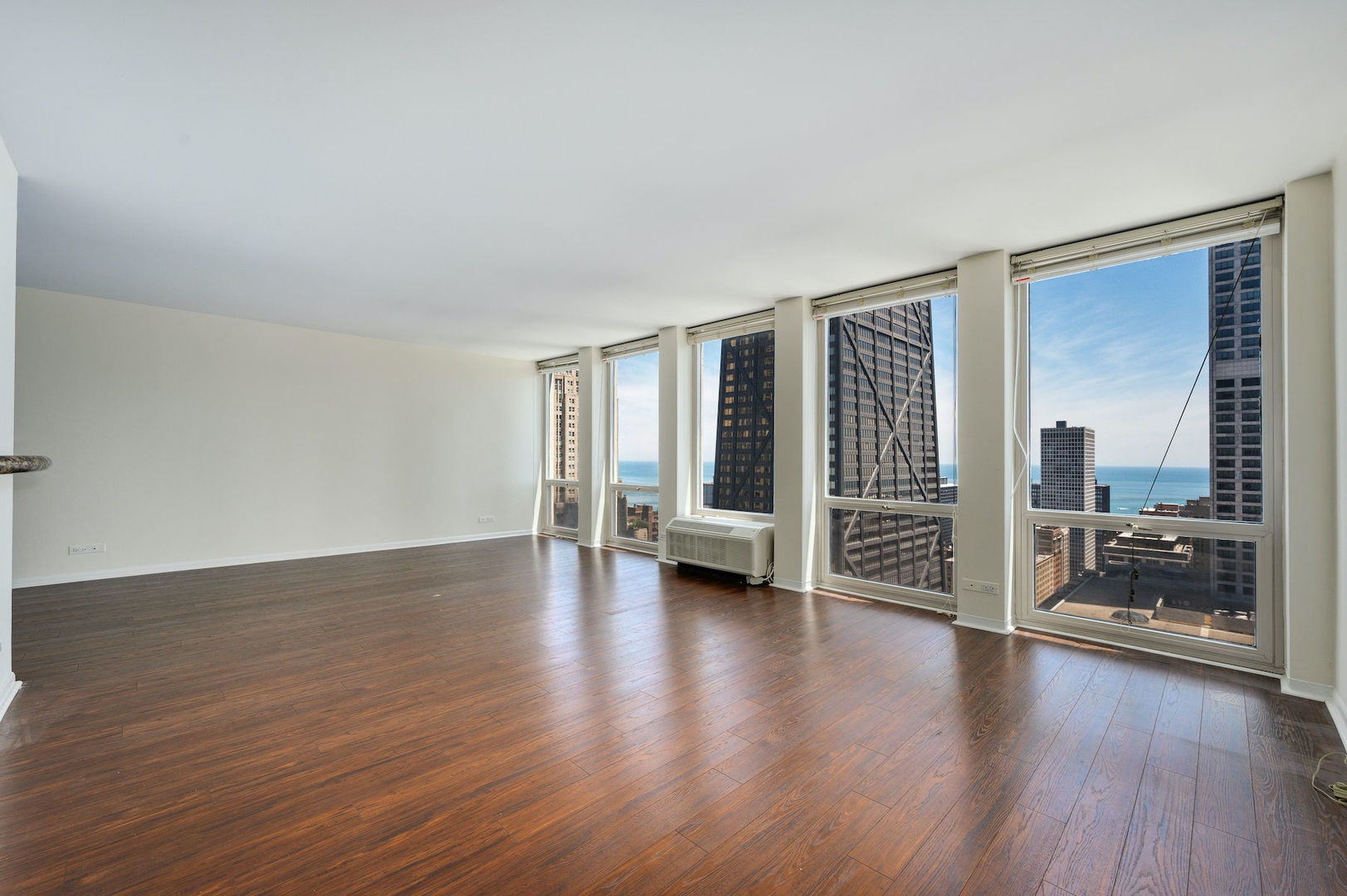 111 East Chestnut Street, Unit 37F Chicago, IL 60611 - Photo 3 of 23 a view of an empty room with wooden floor and a window