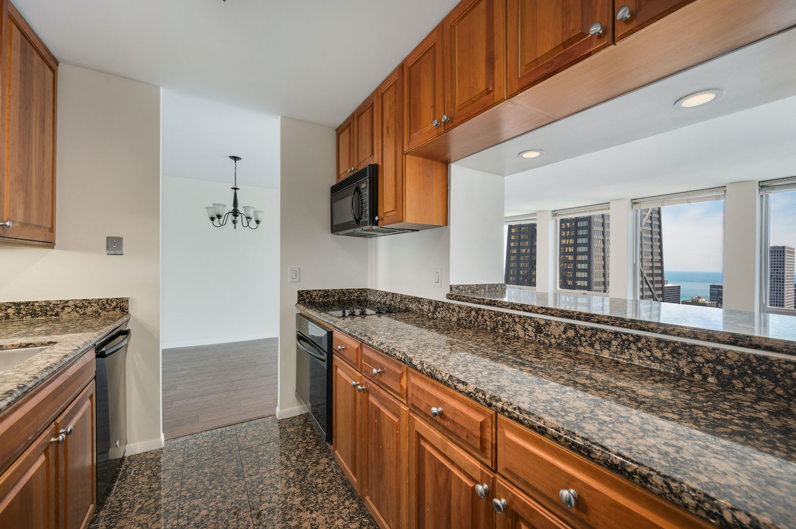 111 East Chestnut Street, Unit 37F Chicago, IL 60611 - Photo 8 of 23 a kitchen with granite countertop a sink stove and cabinets