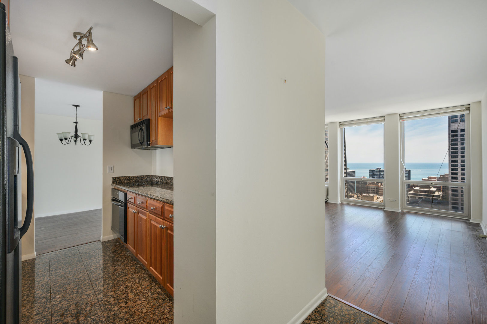 111 East Chestnut Street, Unit 37F Chicago, IL 60611 - Photo 9 of 23 a view of a hallway with wooden floor and a living room