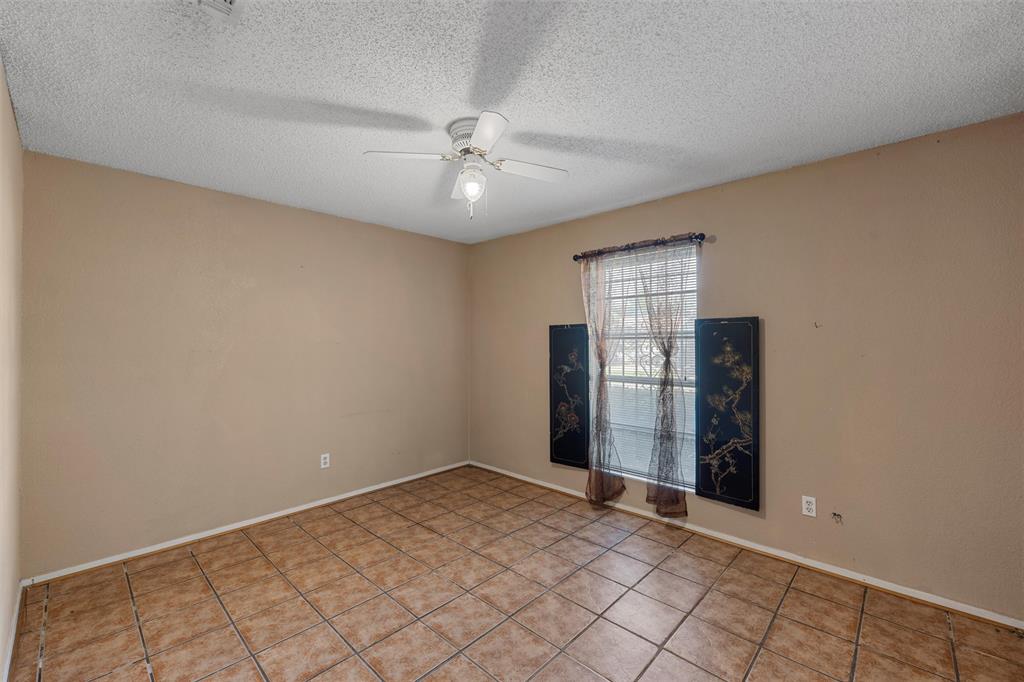 413 Texas Avenue Hewitt, TX 76643 - Photo 14 of 26 Empty room featuring ceiling fan, a textured ceiling, and light tile patterned flooring