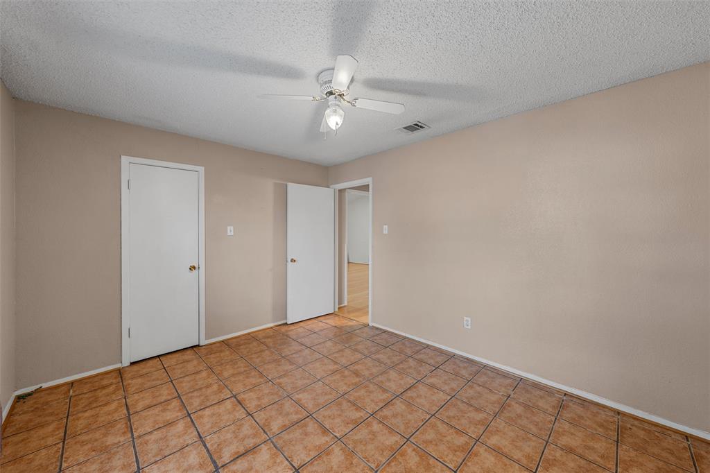 413 Texas Avenue Hewitt, TX 76643 - Photo 15 of 26 Empty room featuring a ceiling fan, a textured ceiling, and light tile patterned floors