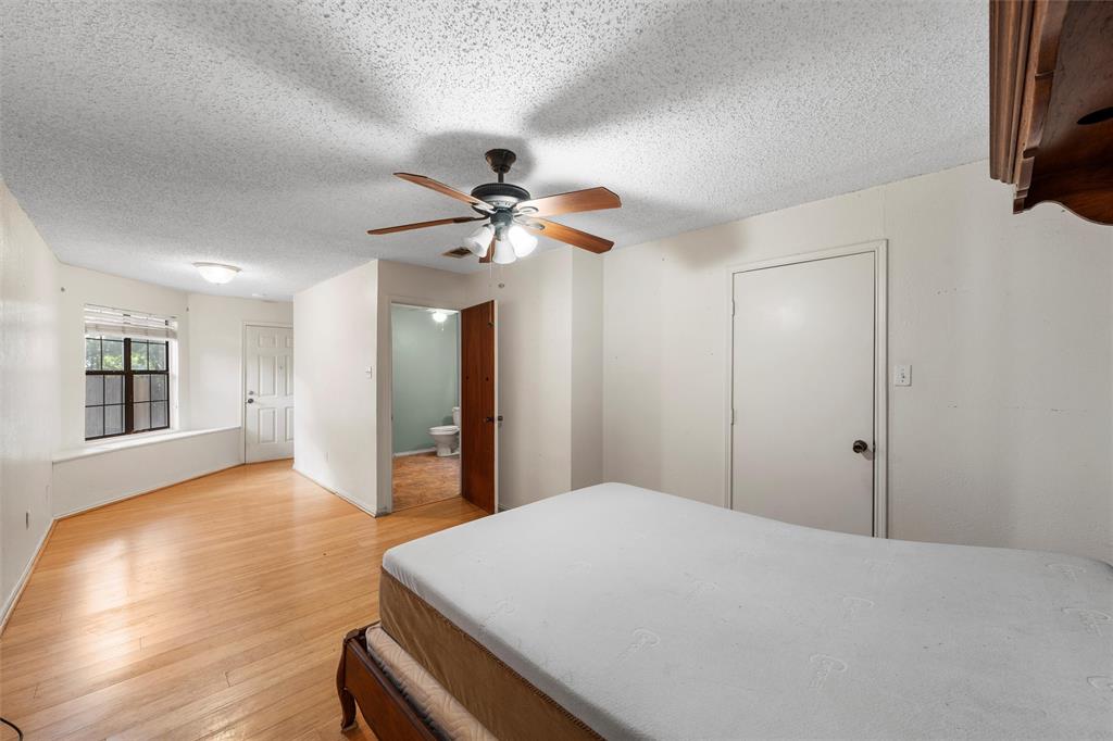 413 Texas Avenue Hewitt, TX 76643 - Photo 20 of 26 Bedroom with light wood-style flooring, a textured ceiling, a ceiling fan, and connected bathroom
