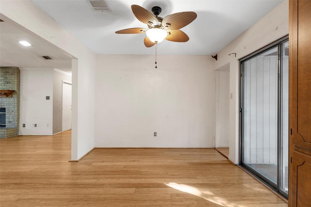 413 Texas Avenue Hewitt, TX 76643 - Photo 7 of 26 Unfurnished room with light wood-style floors, a ceiling fan, and a brick fireplace