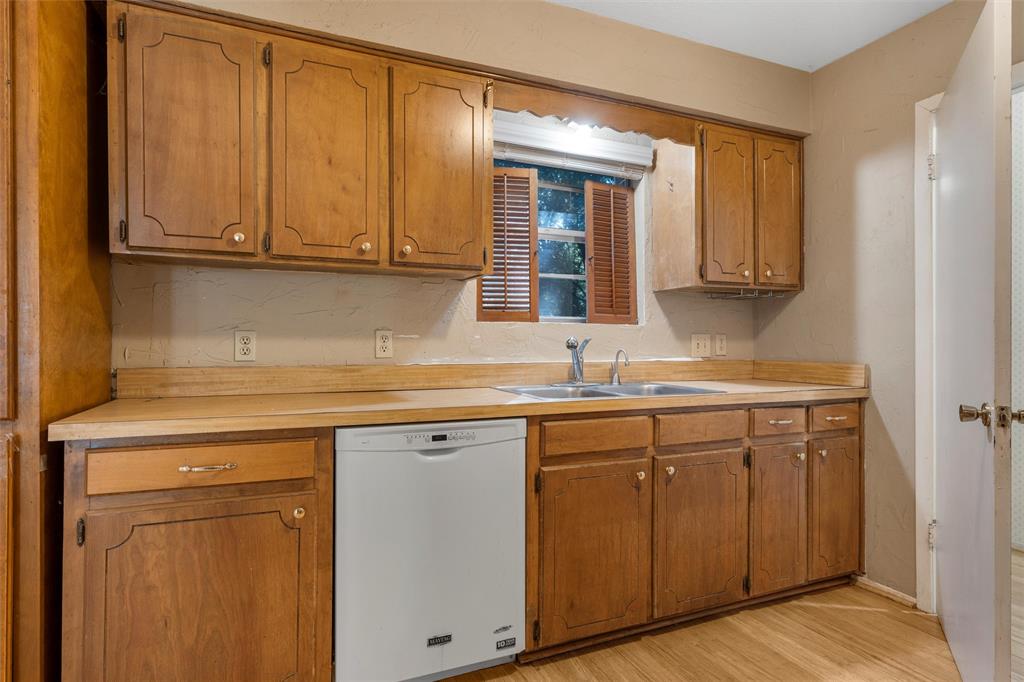 413 Texas Avenue Hewitt, TX 76643 - Photo 9 of 26 Kitchen featuring white dishwasher, light countertops, and brown cabinetry