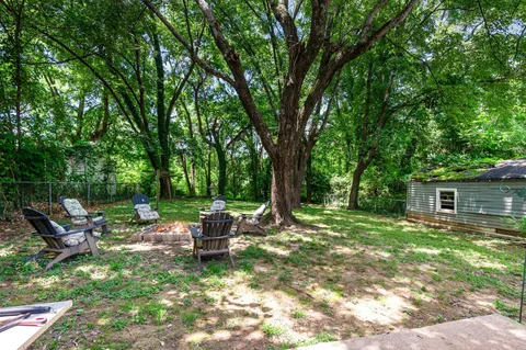 a view of a backyard with table and chairs and a large tree