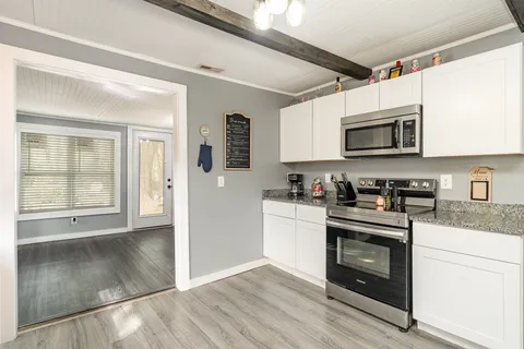 a kitchen with stainless steel appliances granite countertop a stove a microwave and a refrigerator