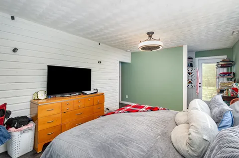 a bedroom with a bed and flat screen tv