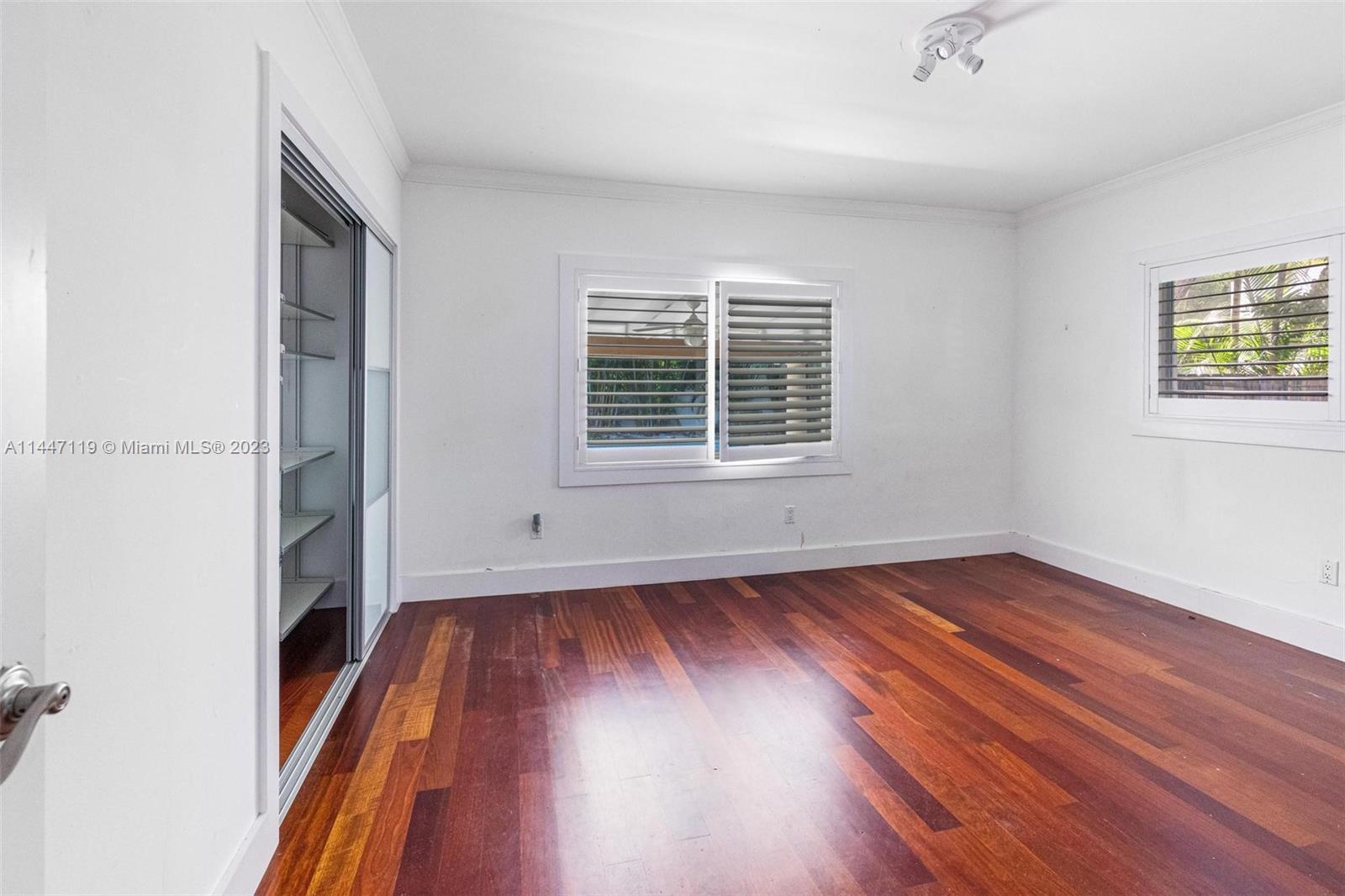 325 Gulf Road Key Biscayne, FL 33149 - Photo 13 of 20 an empty room with wooden floor and windows