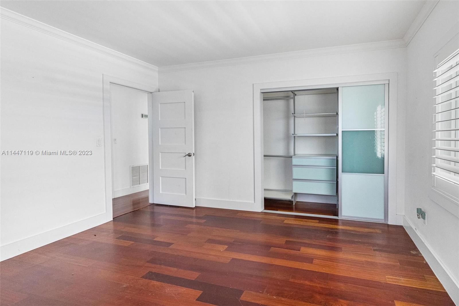 325 Gulf Road Key Biscayne, FL 33149 - Photo 14 of 20 an empty room with wooden floor cabinet and windows