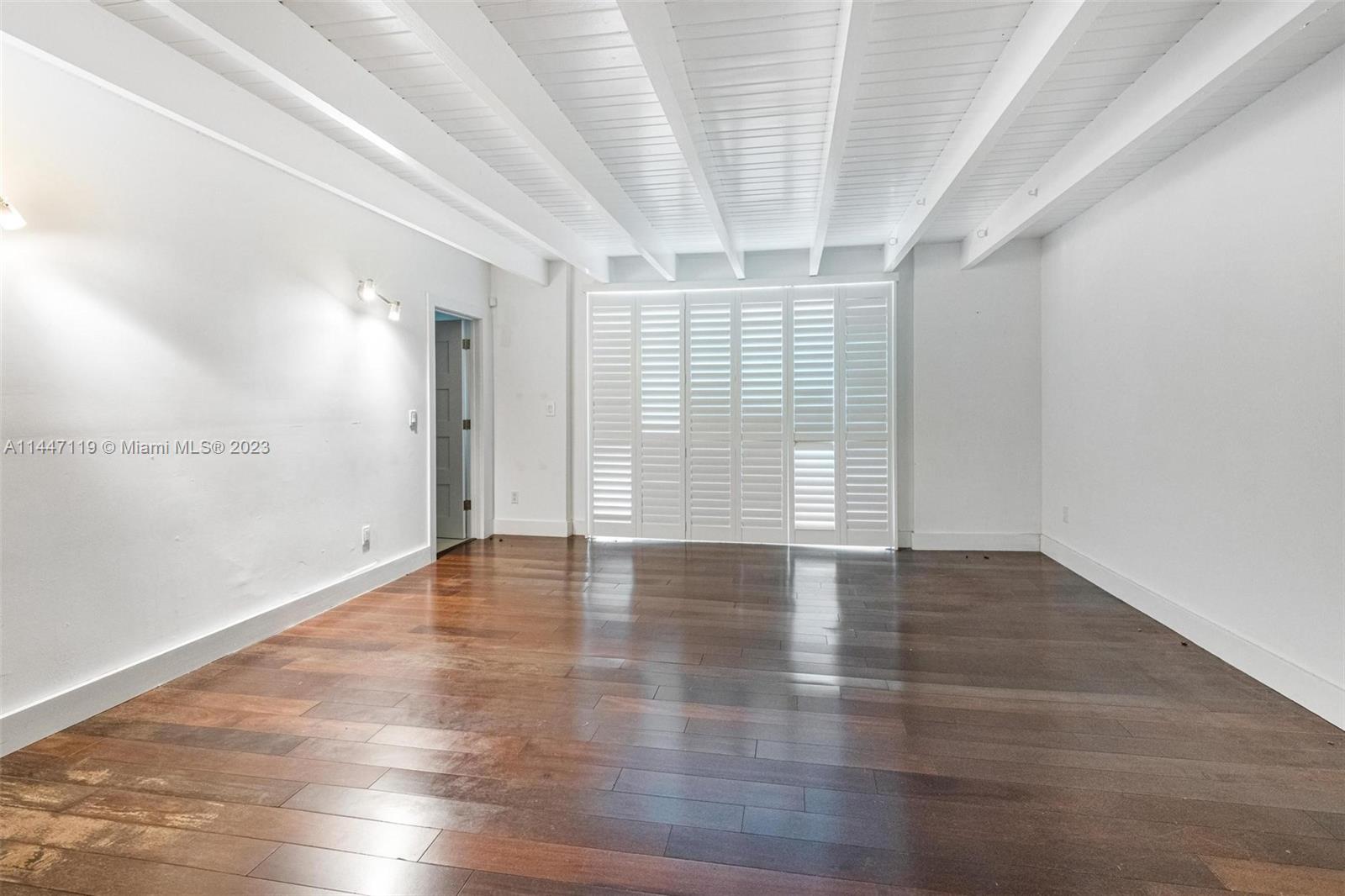 325 Gulf Road Key Biscayne, FL 33149 - Photo 17 of 20 a view of an empty room with wooden floor and a window
