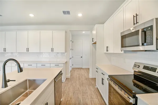 a kitchen with a sink a stove and cabinets